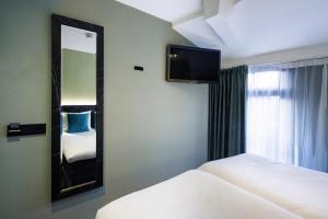 a hotel room with two beds and a mirror at Ciao Papa Hotel Amsterdam Central Station in Amsterdam