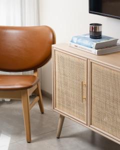 a brown chair sitting next to a table with a tv at AMALON Boutique Apartments in Jerusalem