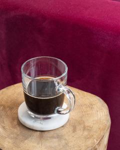 a glass cup of coffee sitting on a table at AMALON Boutique Apartments in Jerusalem