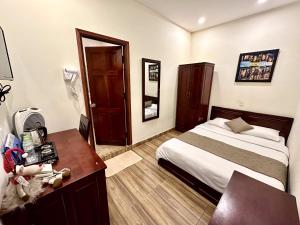 a hotel room with a bed and a desk and a desk at Nam Xuan Premium Hotel in Da Lat