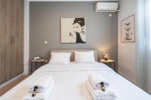 a bedroom with a large white bed with towels on it at Modern Apartment in Exarchia in Athens