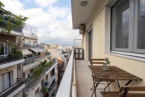 a balcony with a wooden table and a view of a city at Modern Apartment in Exarchia in Athens