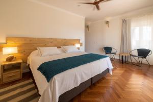 Schlafzimmer mit einem großen Bett mit einem Kopfteil aus Holz in der Unterkunft Quinta Marugo Retreats in Serpa