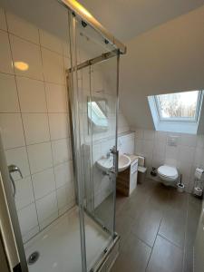 uma casa de banho com um chuveiro, um lavatório e um WC. em Hugo em Gelsenkirchen
