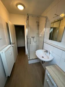 uma casa de banho com um lavatório e um chuveiro em Hugo em Gelsenkirchen
