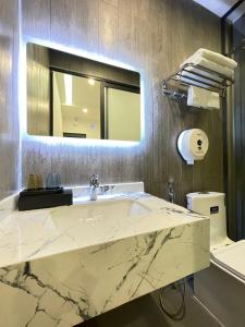 y baño con lavabo de mármol y espejo. en TÂY NINH CITY HOTEL, en Tây Ninh
