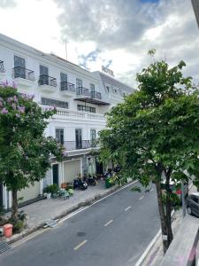 un gran edificio blanco en una calle con árboles en TÂY NINH CITY HOTEL, en Tây Ninh