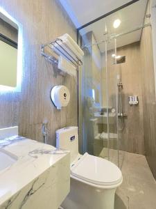 a bathroom with a toilet and a glass shower at TÂY NINH CITY HOTEL in Tây Ninh