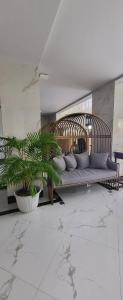 Baan Thanakul Residences في ساموتبراكارن: أريكة في غرفة بها اثنين من النباتات الفخارية