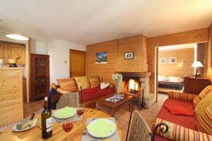 a living room with a couch and a fireplace at Cosy Appart'Hotel - Panoramic Village - La Grave in La Grave