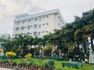 a large white building with a park in front of it at Hotel Bali Resort extension in Katra
