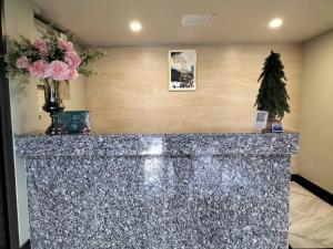 a lobby with a granite counter top with flowers at Baan Thanakul Residences in Samutprakarn