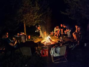 a group of people sitting around a campfire at night at "Grzesiówka" in Czarnożyły