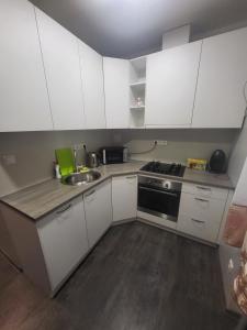 a kitchen with white cabinets and a sink at Kiviõli Apartment in Kiviõli