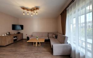 ein Wohnzimmer mit einem Sofa und einem Tisch in der Unterkunft Complex YustinaVillas in Ustina