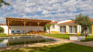 un patio trasero con piscina y pérgola en Quinta Marugo Retreats en Serpa