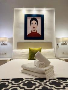 - une chambre avec un lit et un portrait d'un homme dans l'établissement Bonito Apartamento a un paso del centro., à Séville
