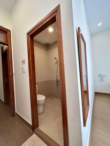 a bathroom with a toilet and a mirror at Nam Xuan Premium Hotel in Da Lat