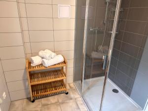 uma casa de banho com um chuveiro e toalhas num suporte em Apartmány na mlýně em Nové Město na Moravě