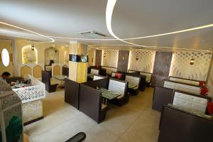 ein Restaurant mit Tischen und Stühlen in einem Zimmer in der Unterkunft Hotel Darbar-E-Khas A member of Crimson Hotels in Bareilly