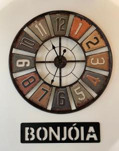 un reloj colgando en una pared sobre una señal de bonda en Bonjóia Porto Guest House, en Oporto