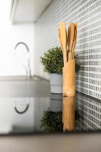two wooden utensils sitting on a counter next to a plant at Deluxe Quentin Home next to the Fashion Street in Budapest