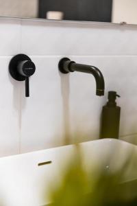 a sink with a faucet in a bathroom at Deluxe Quentin Home next to the Fashion Street in Budapest