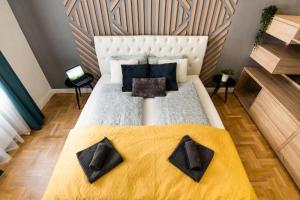 een slaapkamer met een groot bed met zwarte kussens bij Deluxe Quentin Home next to the Fashion Street in Boedapest