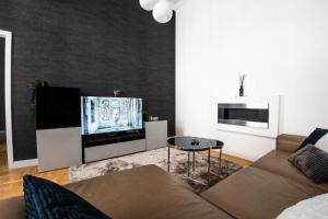 a living room with a couch and a flat screen tv at Deluxe Quentin Home next to the Fashion Street in Budapest