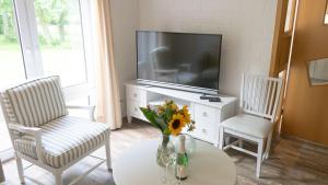 a living room with a tv and two chairs and a table at Warfblick - Landlust Osterwarf in Norddeich