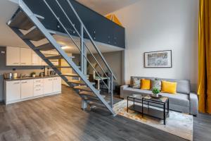 sala de estar con sofá y escalera en Global Living - Deluxe Rakoczi Residence By Bella, en Budapest
