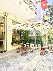 a group of tables and benches in front of a hotel at Nam Xuan Premium Hotel in Da Lat