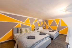 2 camas en una habitación con paredes coloridas en Global Living - Deluxe Rakoczi Residence By Bella en Budapest