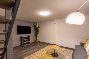 sala de estar con sofá y TV en Global Living - Deluxe Rakoczi Residence By Bella en Budapest