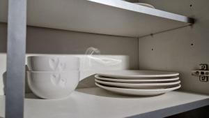 a pile of plates and bowls sitting on a shelf at Spacious 1 Br Near Lincoln City Centre Amenities in Lincoln