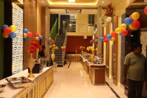 a man is standing in a hallway with balloons at Hotel Prem Residency in Patna