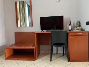 a desk with a computer and a chair and a television at Hotel Ristorante Cervo Malpensa in Case Nuove