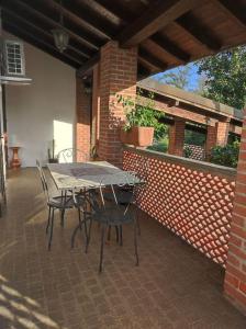 un patio con tavolo e sedie su un muro di mattoni di La casa della Nonna a Gambolò