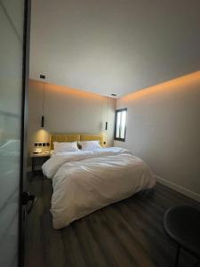 a bedroom with a large bed with white sheets at صممت للاسترخاء in Riyadh