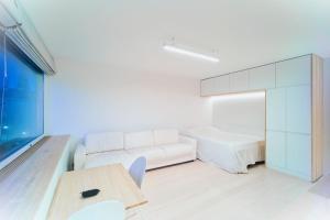 ヘルシンキにあるCentral Studio Nordic Styleの白いソファとテーブル付きの白いベッドルーム