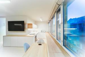 ヘルシンキにあるCentral Studio Nordic Styleのキッチン(木製テーブル付)、大きな窓が備わります。
