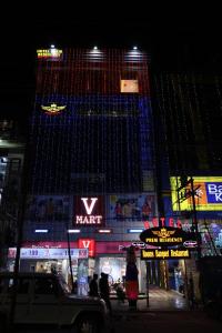 un palazzo alto con luci accese di notte di Hotel Prem Residency a Patna