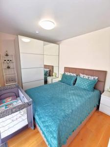 um quarto com uma cama grande e um edredão azul em Cozy Palanga em Palanga