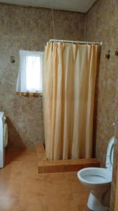 a bathroom with a shower curtain and a toilet at Hotel Casa Sinkinling Gambia in Sere Kunda