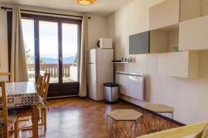 kuchnia z lodówką, stołem i krzesłami w obiekcie T2 cabine avec terrasse plein sud 30m2 aux angles w mieście Les Angles +5 zdjęć