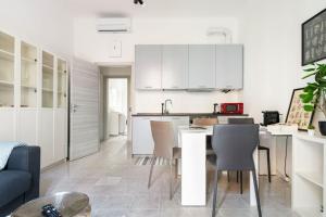 cocina con armarios blancos, mesa y sillas en La casa sull'albero City Life, en Milán