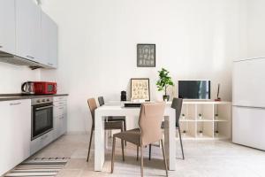 a kitchen with a white table and chairs in a room at La casa sull'albero City Life in Milan