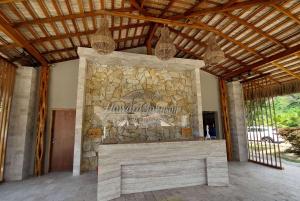 a stone fireplace in a house with a stone wall at Howard Johnson by Wyndham Montañita in Montañita