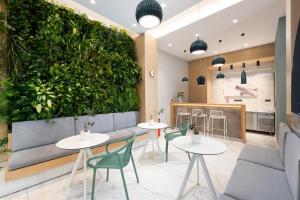 a restaurant with tables and a green wall at Enattica Suites in Athens