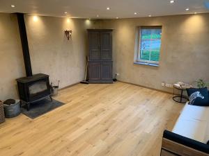 a living room with a woodburning stove in a room at L'Oeil du Condroz in Clavier